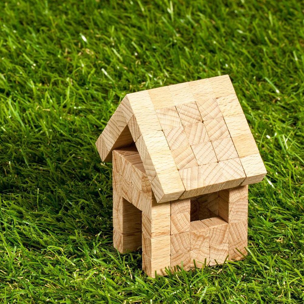 Une petite maison en bois sur l'herbe